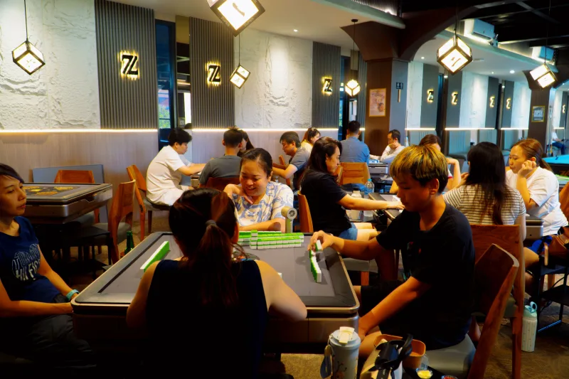 Pengunjung bermain mahjong di meja otomatis Zuper Club
